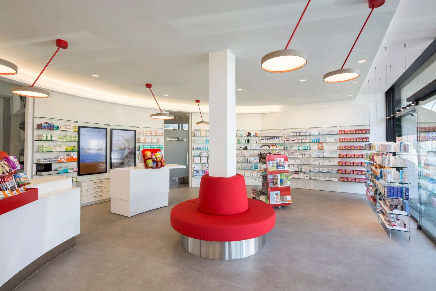 Blickfang im halbkreisförmigen Apothekenverkaufsraum die kreisförmige Bank im Zentrum.
