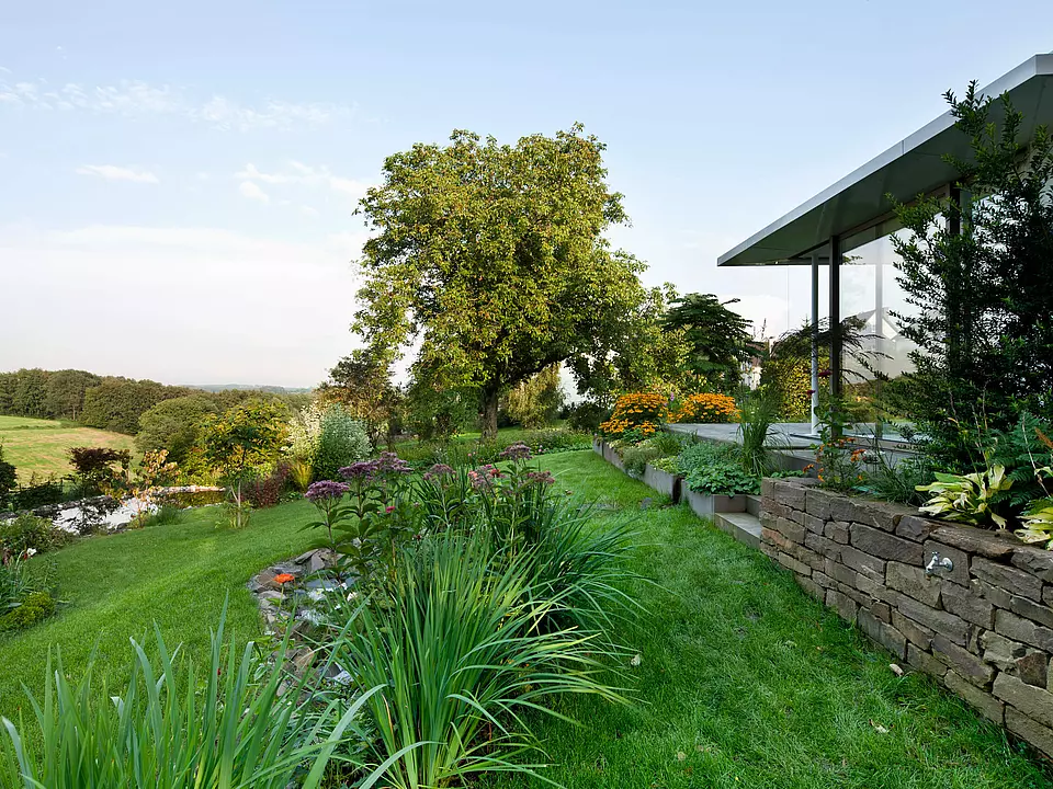 Moderner Anbau mit Gartenanlage.