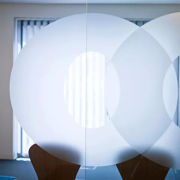 Glasschiebetüren mit großen Os aus dem Firmenlogo. 