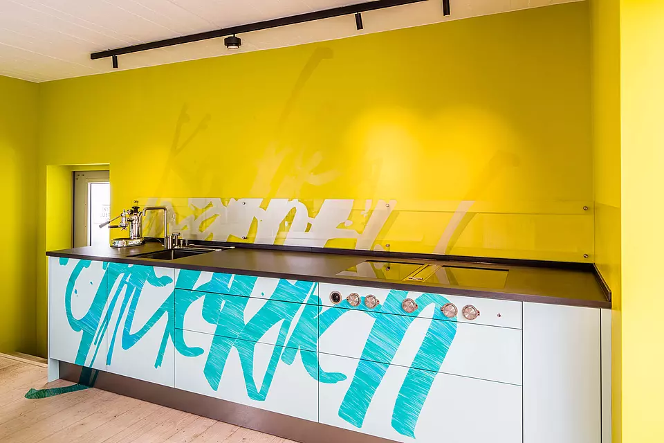 Grafik über Boden, Möbel, Wand. "Kochen macht glücklich".