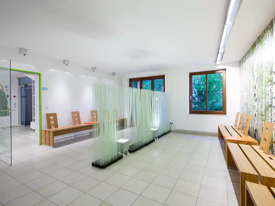 Tierarztwartezimmer mit Raumteilersystem und modernen Holzbänken.